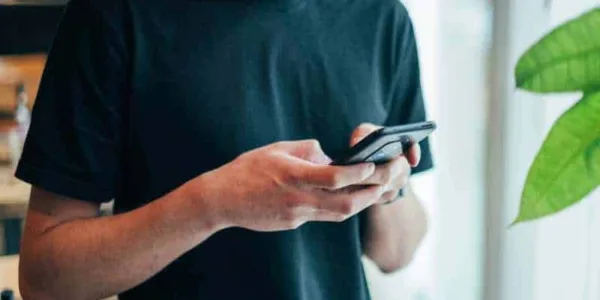 man-typing-phone-at-cafe