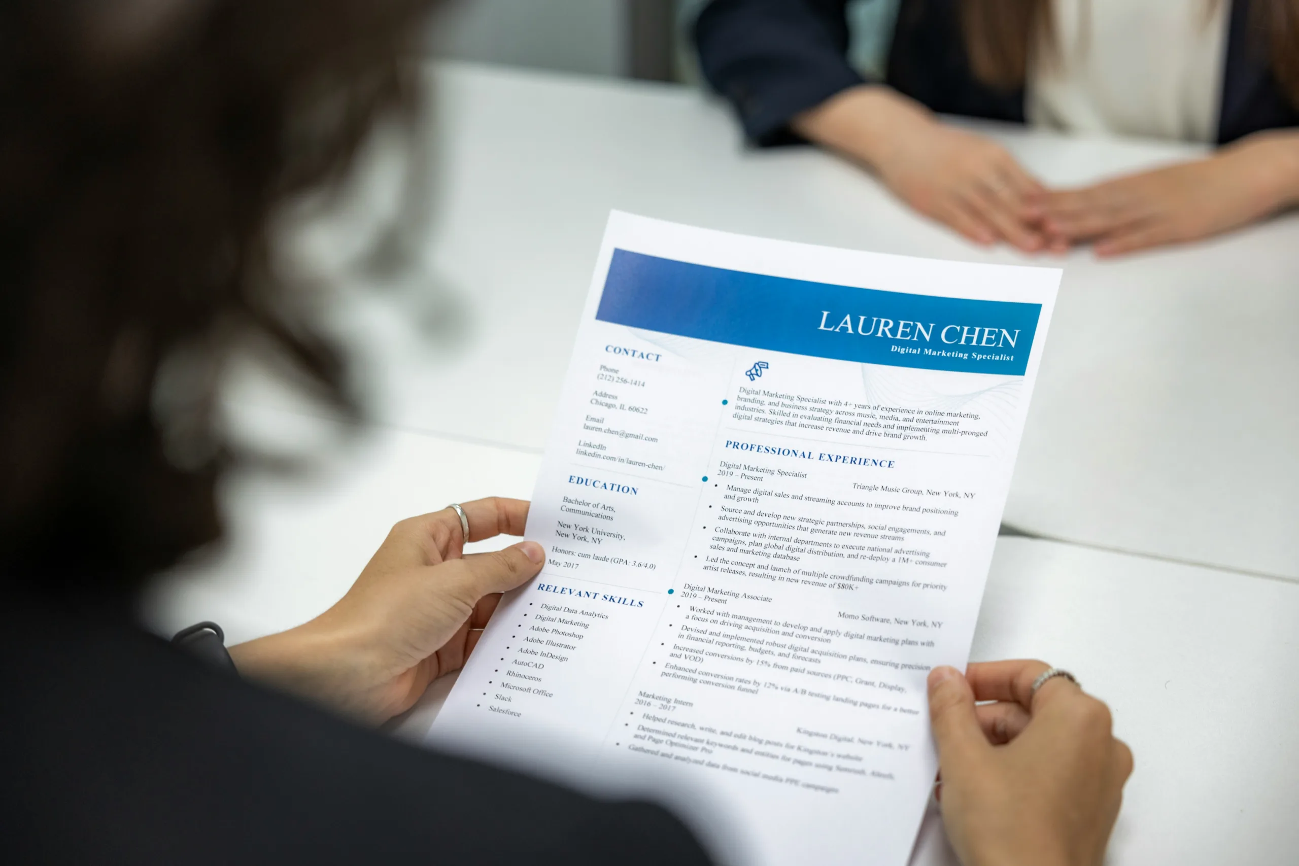 Recruiter reviewing a candidate's resume during a job interview, highlighting employment history, qualifications, and professional experience for hiring evaluation.